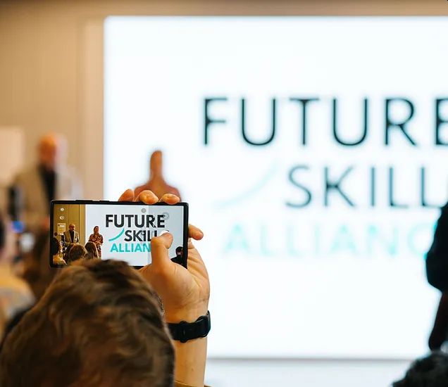 Eine Person fotografiert die Präsentation der Future Skills Alliance